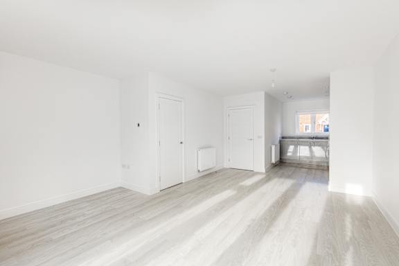 A white room with wooden floors and white walls.