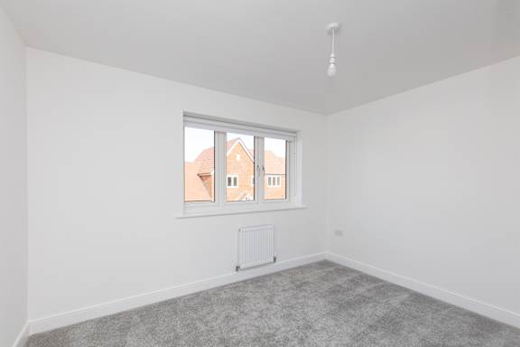 A room with a window showing a view of a building outside.