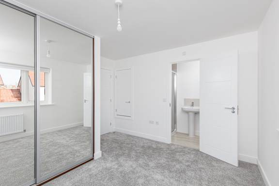 A white room with a glass door and a grey carpet.