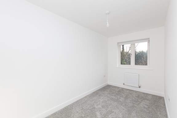 A room with a window and a radiator on the wall.