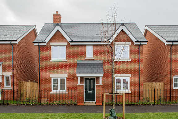 A red brick house with a black door and windows.