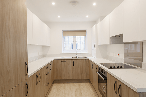 A modern kitchen with wooden cabinets and a window.