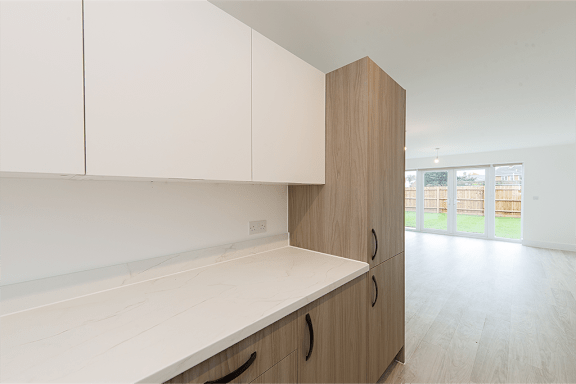 A kitchen with white cabinets and a wooden island.