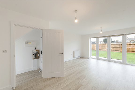 A room with a white door and a white wall.
