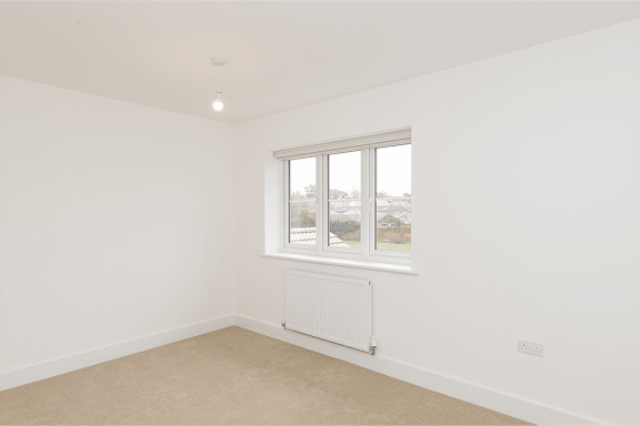 A room with a window and a radiator on the wall.