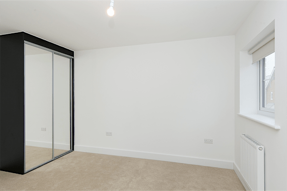 A room with a black wardrobe and a sliding door.