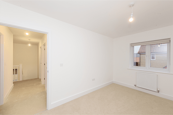 A room with a window and a radiator on the wall.