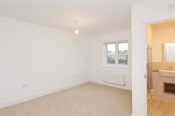 A room with a window and a radiator on the wall.