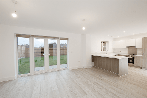 A spacious kitchen and living room with a view of a backyard.