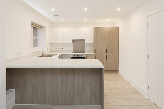 A modern kitchen with wooden cabinets and a white countertop.