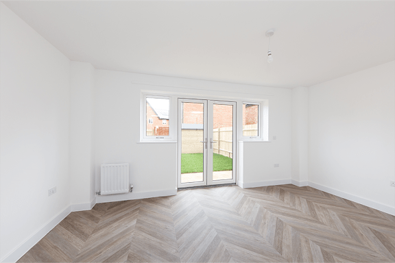 A room with a wooden floor and a sliding glass door.