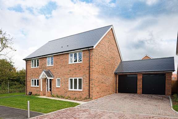 A red brick house with a black garage door.