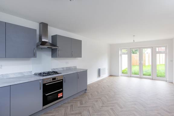 A kitchen with a stove top oven and a range hood.