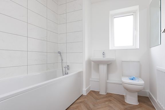 A white bathroom with a tub, toilet, and sink.