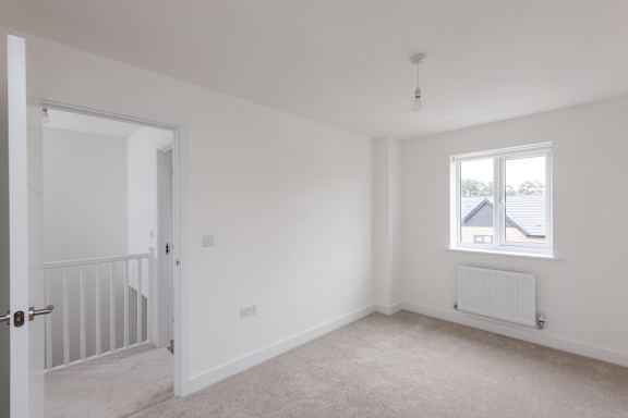 A white room with a window and a radiator.