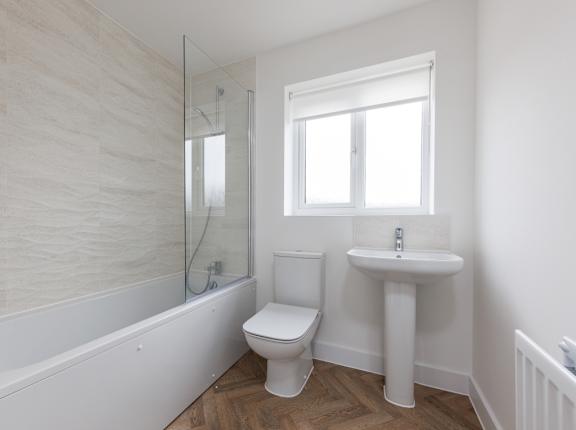 A white bathroom with a toilet, sink, and bathtub.