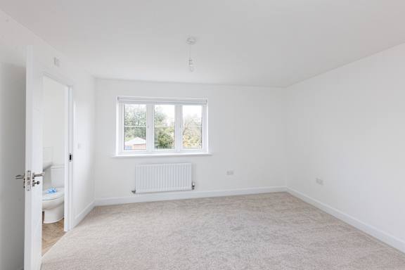 A white room with a window and a radiator.