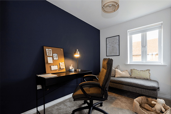A room with a desk, chair, and a couch.