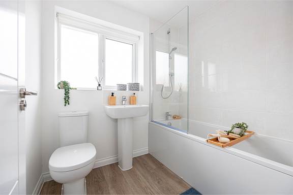 A white bathroom with a toilet, sink, and bathtub.