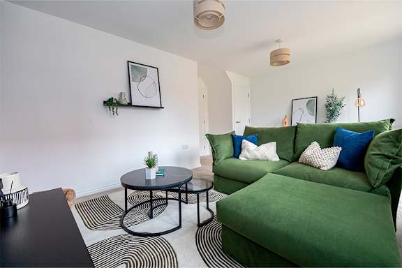 A living room with a green couch and a black table.