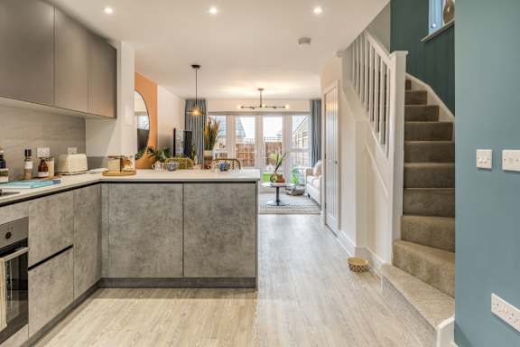 A modern kitchen with a stainless steel oven and a wooden floor.