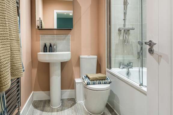 A bathroom with a toilet, sink, and shower.