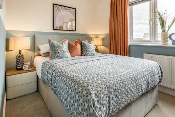 A bed with a blue and white patterned comforter is in the image.