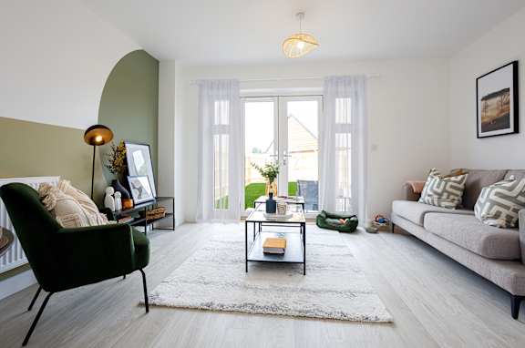 A living room with a green chair and a grey couch.