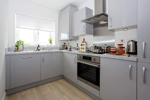 A modern kitchen with white cabinets and stainless steel appliances.