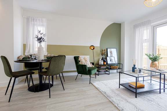 A modern dining room with a glass table and chairs.