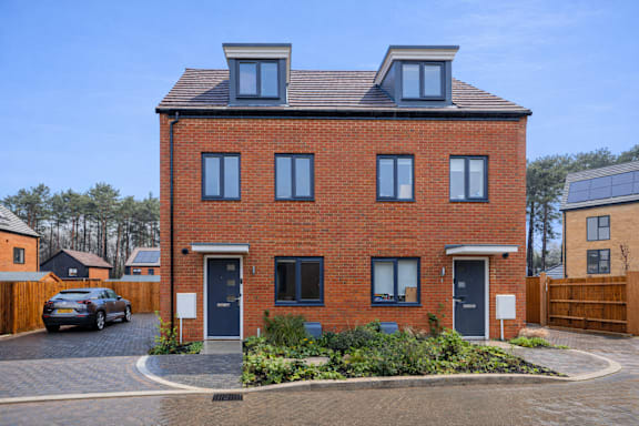 A red brick house with a black door and windows.