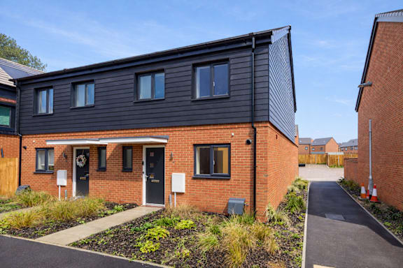 A modern house with a black front and a grey roof.