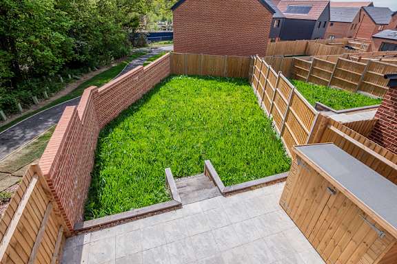 A backyard with a wooden fence and a brick wall.