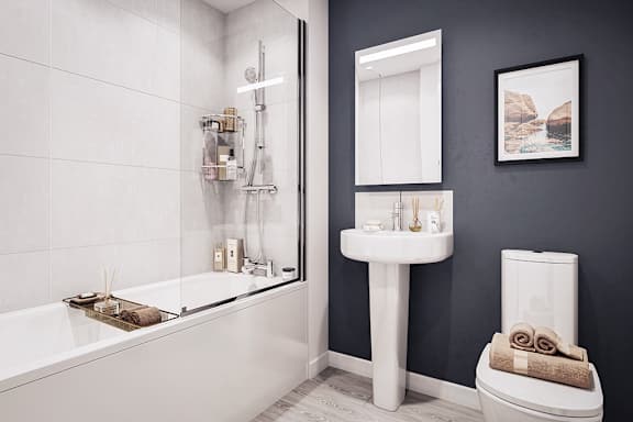 A modern bathroom with a white bathtub, sink, and toilet.