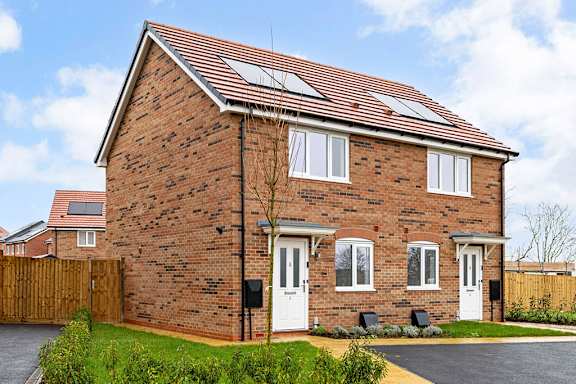 A brick house with a white door and windows.
