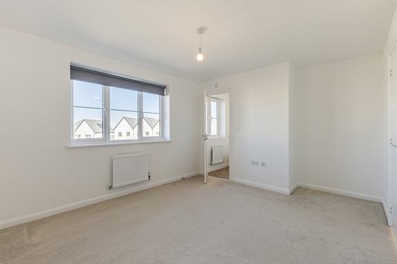 A room with a window and a radiator on the wall.