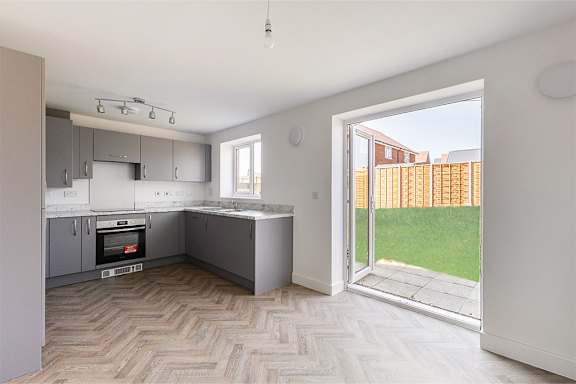 A kitchen with a white oven and a window.