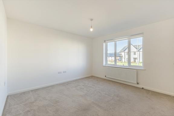 A room with a window and a radiator on the wall.
