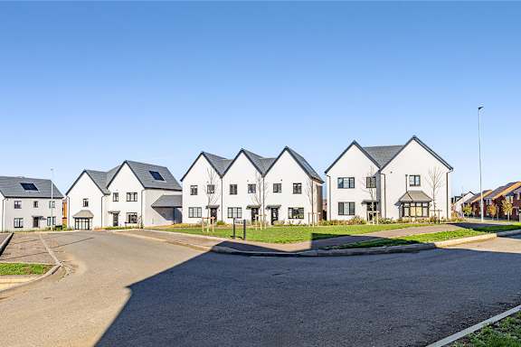A row of white houses with a clear blue sky above.