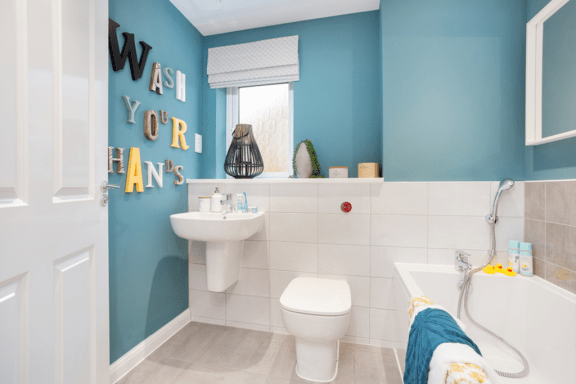 a bathroom with a toilet sink and tub and a wall that says wash your hands