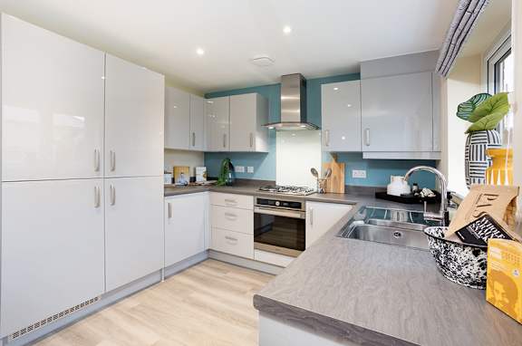 A modern kitchen with white cabinets and a wooden countertop.