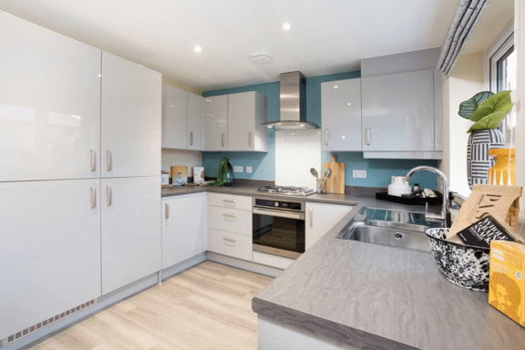 a kitchen with white cabinets and stainless steel appliances and a grey counter top