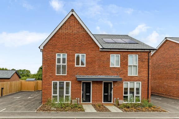 A red brick house with a black door and windows.