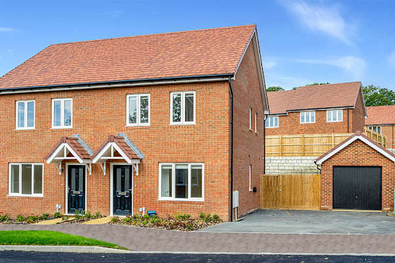 A red brick house with a black garage door.