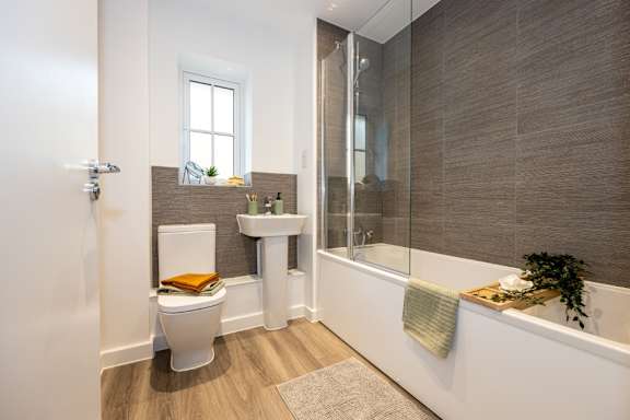 A modern bathroom with a white toilet, a white sink, and a white bathtub.