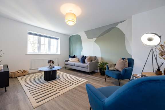 A living room with a blue chair and a white couch.