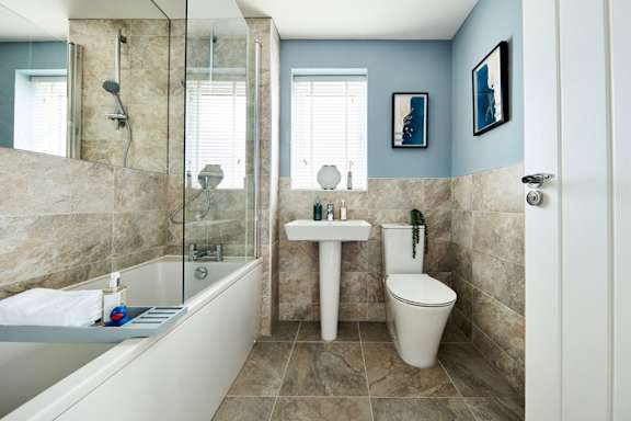 A bathroom with a tub, sink, and toilet.