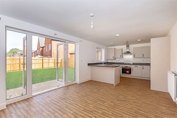 A kitchen with a wooden floor and white walls.