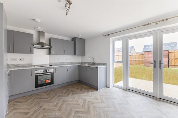A modern kitchen with a white oven and a white stove.