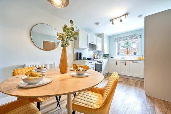 A modern kitchen with a round table and chairs.